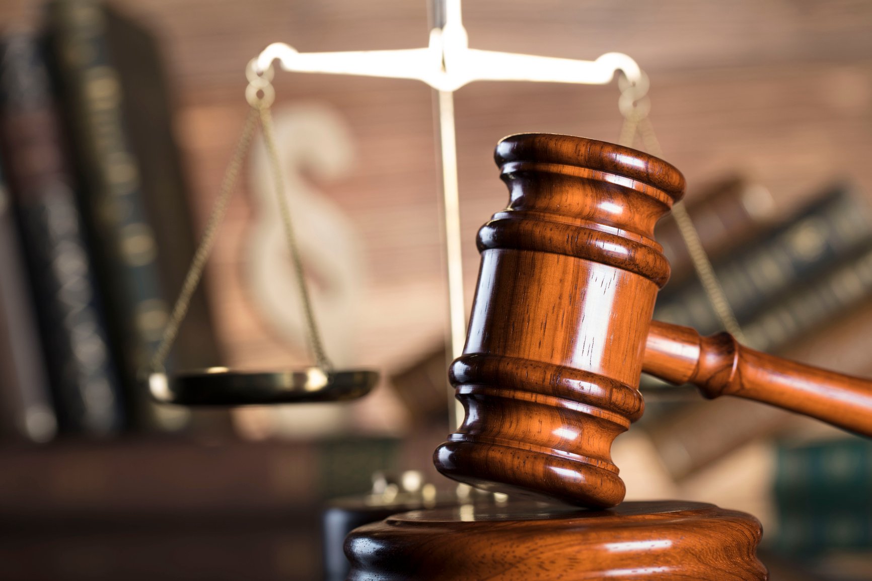 judge's gavel and scales of justice on a wooden table